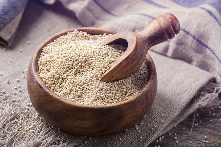 White quinoa seeds on a wooden background