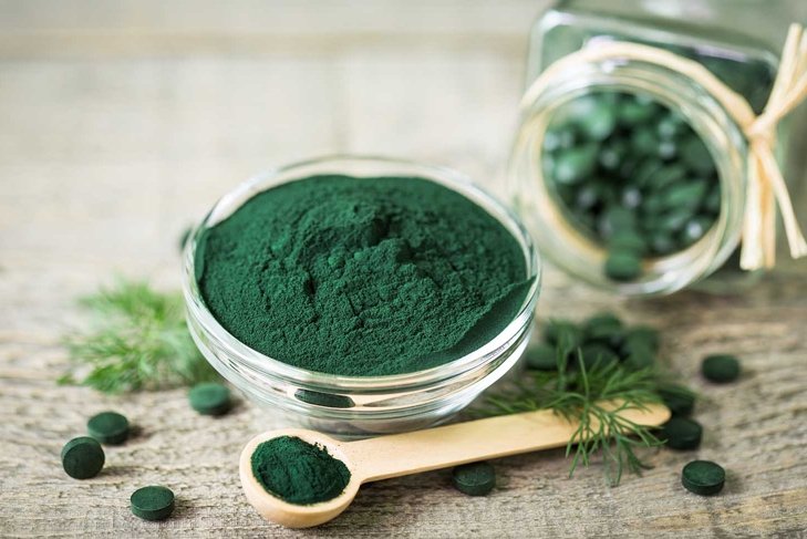 Spirulina powder and tablets in the bowl