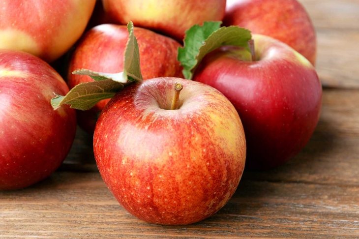 Ripe red apples on wooden background