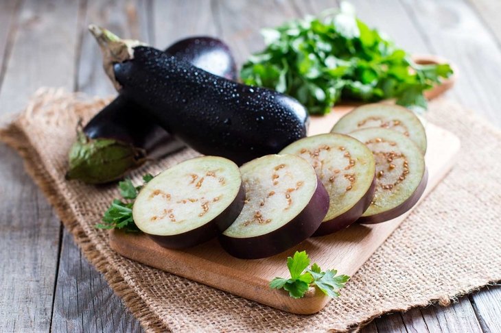 Sliced eggplant on wooden cutting board