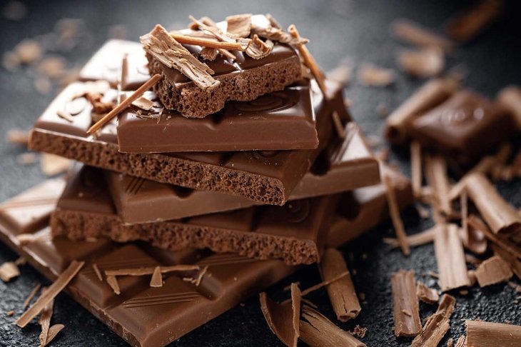 Broken chocolate bars on dark background. Closeup. Chocolate background . Closeup