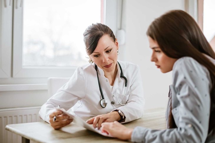 Charming female doctor giving advice to a female patient.