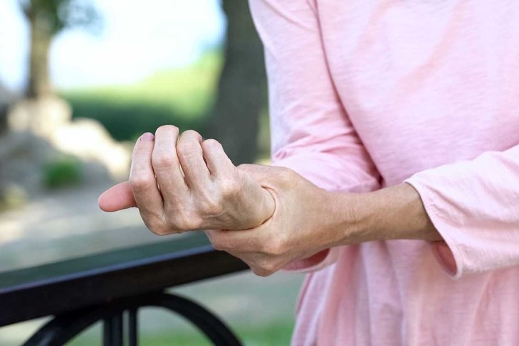 Old woman stretching numb arm, weakness of muscles in senior age, arthritis